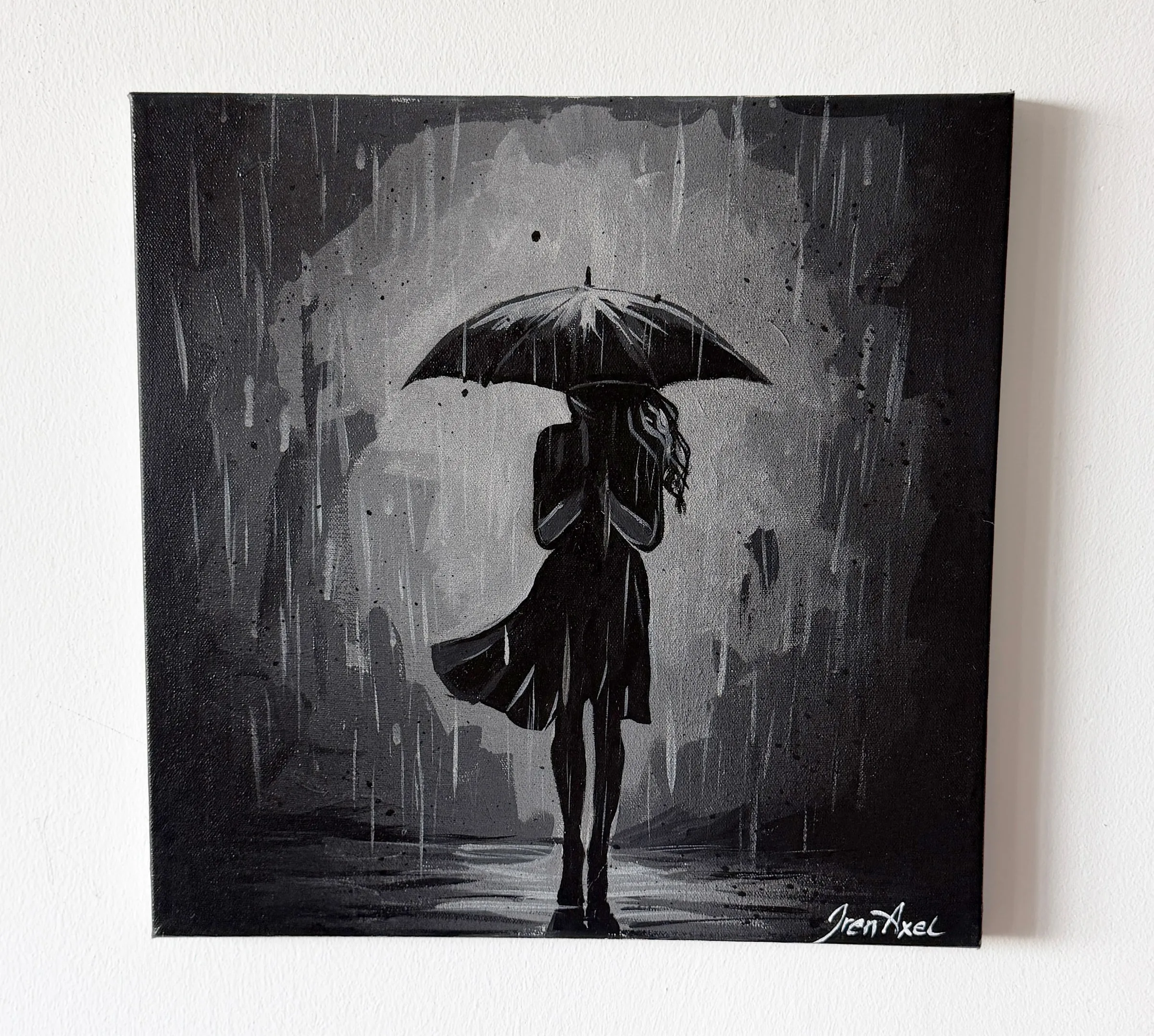 Hanging on a white wall: monochrome painting of a woman under an umbrella in the rain