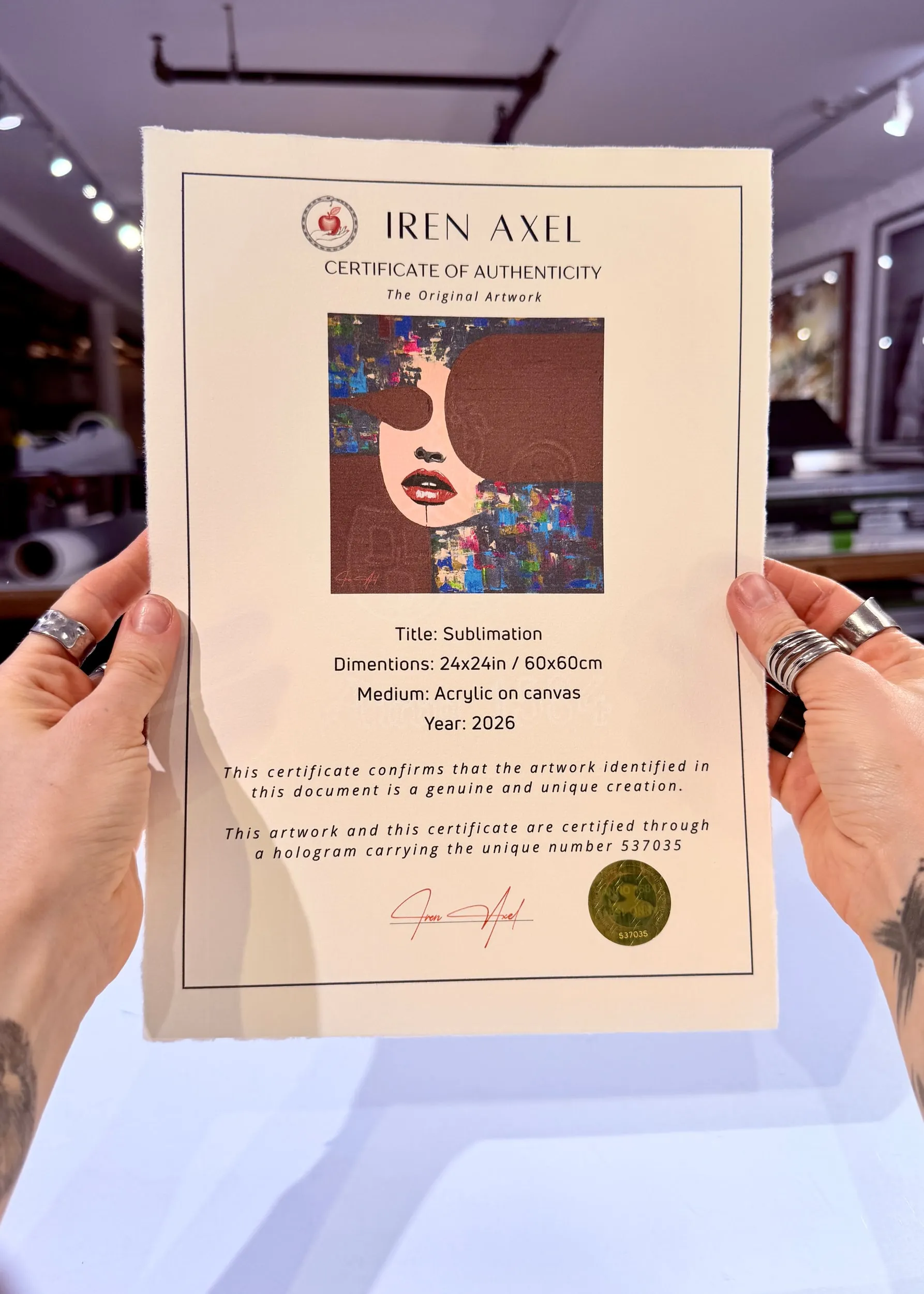 The signed certificate of authenticity for Sublimation, hologram number 537035, held up in the gallery